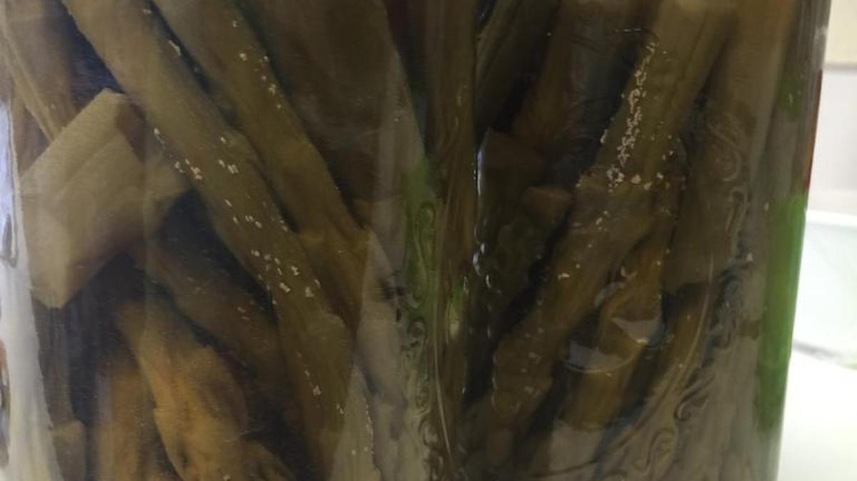 The little white flakes that appear on pickled asparagus are called rutin and are safe to eat.
