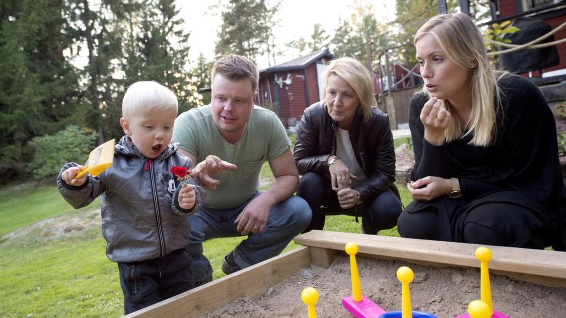 Albin, left, plays by the sand pit as his mother Emelie Eriksson, right, his grandmother Marie, second right, and his father Daniel look on outside their home in Bergshamra, Sweden. Eriksson was the first woman to have a baby after receiving a womb transplant from her mother, a revolutionary operation that links three generations of their family.