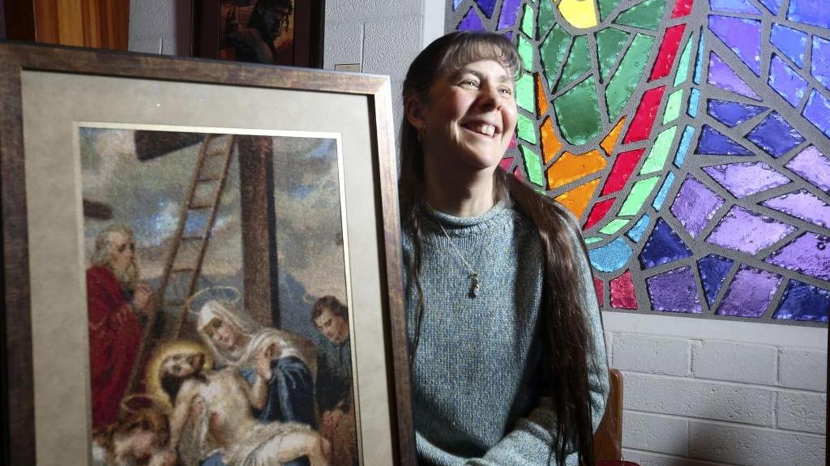 Lisa Richmond, parish administrator, holds one of the pieces she cross-stitched for All Saints’ Episcopal Church’s homegrown Stations of the Cross project. The 14 stations, depicting the path Jesus took through his crucifixion and burial, were created by members of the Richland church.