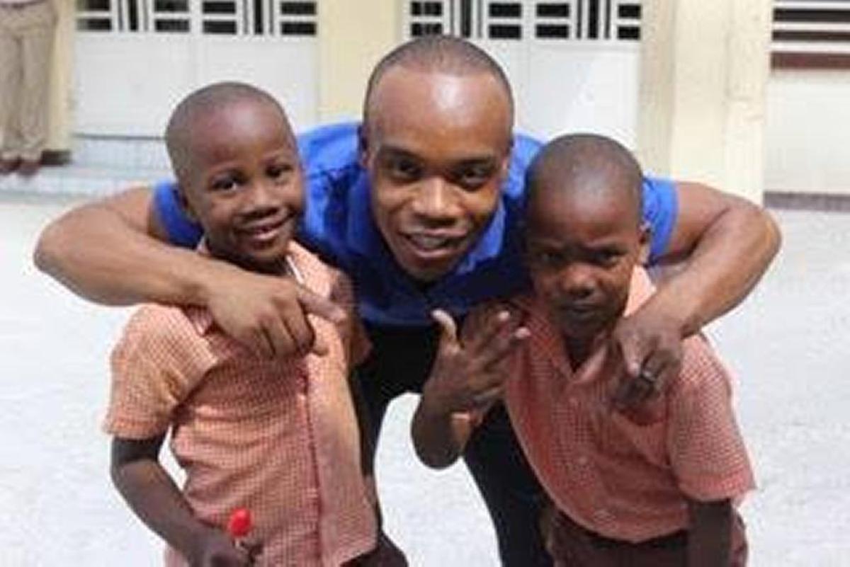 Dexter McKinley, once an orphan in Haiti, holds two boys close during an orphanage visit in February 2017.