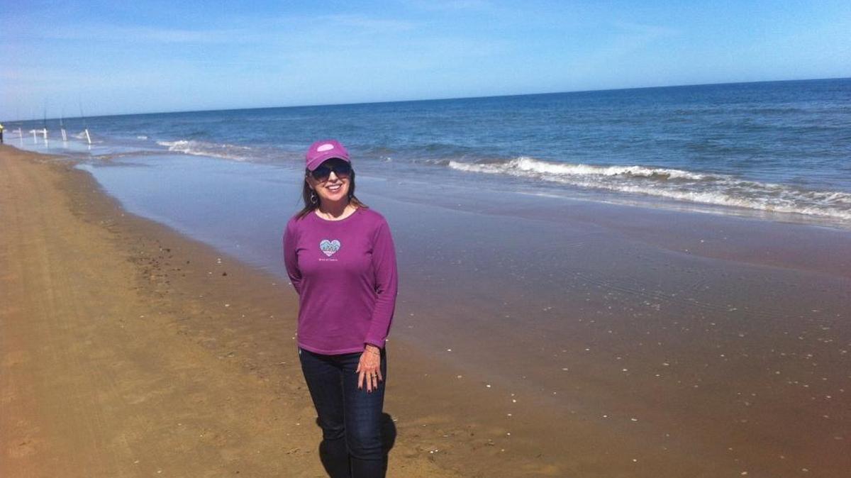 Lucy Luginbill stands on the empty South Padre Island beach where she met Melissa by “chance.”