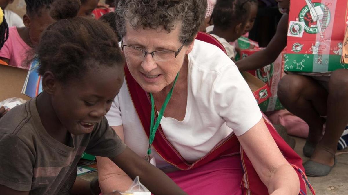 Janet Clark of Walla Walla gets acquainted with a youngster in Zambia, Africa, while handing out Operation Christmas Child shoeboxes.