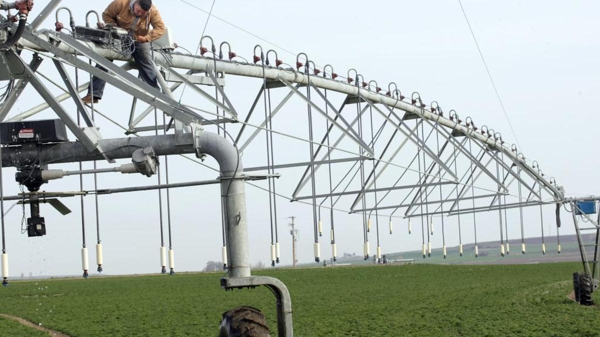 An employee of Wray Hay farm in Franklin County repairs to a center-pivot irrigation system on Glade Road North about seven miles north of Pasco in this file photo.