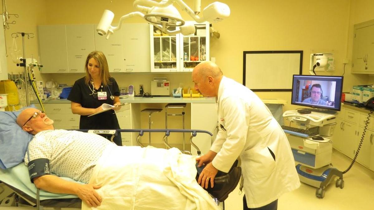 Dr. Lewis Neace, right, director of the emergency department at Dayton General Hospital, speaks with a demonstration patient during a stroke simulation at the rural hospital, as Seattle neurologist Dr. Todd Czartoski looks on via a telehealth unit. Providence St. Joseph Health’s telehealth program connects rural hospitals like Dayton General with specialists such as Czartoski.