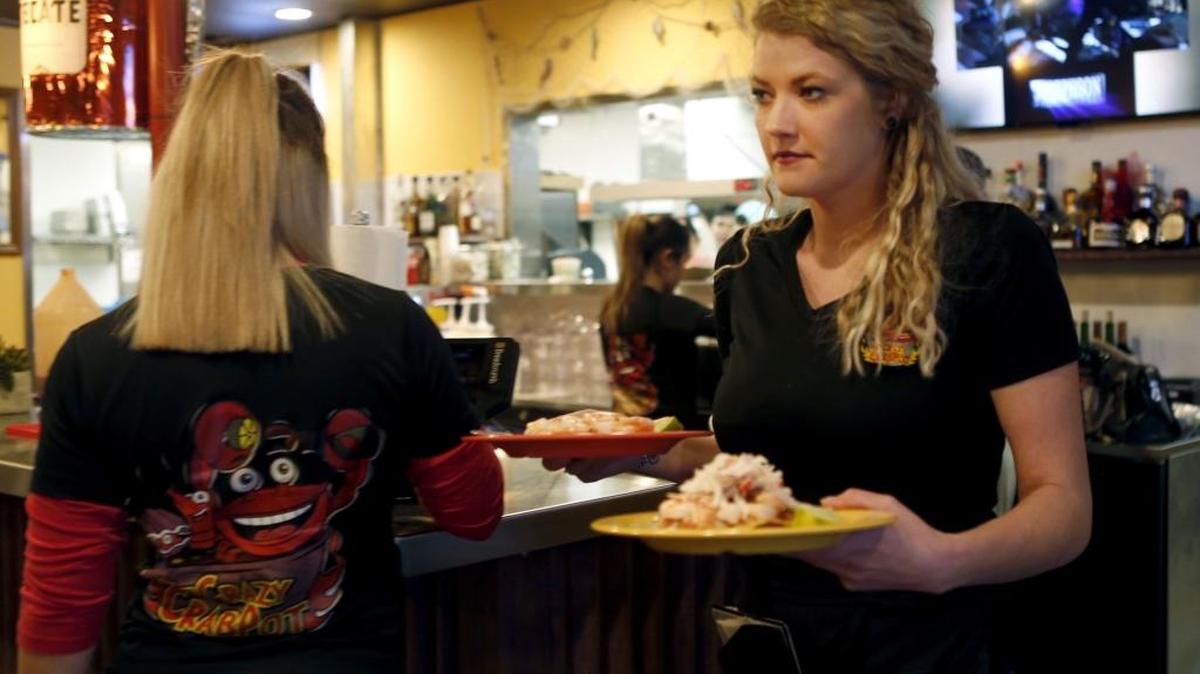 Cortney Cagle, a waitress at Crazy Crab Pot, carries out plates of food Tuesday at the Kennewick restaurant, which opened in November.