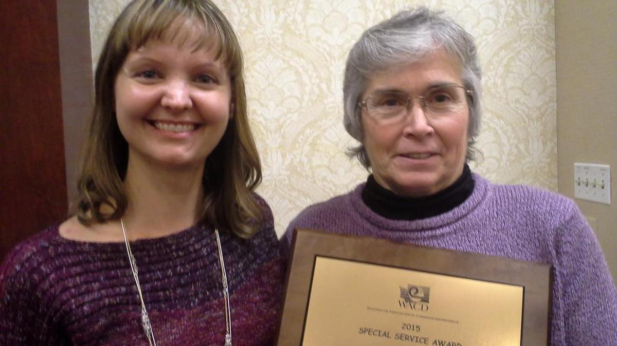 Benton Conservation District assistant manager Heather Wendt, left, and volunteer Donna Lucas hold the 2015 Special Service Award that was presented to Lucas by the Washington Association of Conservation Districts.
