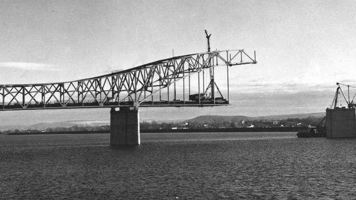 This photo captures the progress of the Blue Bridge as of January, 1954. As the huge steel span from the Pasco bank of the Columbia River stretched toward the Kennewick side, workers turned their effort toward the second section. Work progressed rapidly—except for five or six days lost due to cold weather—and the spans joined mid-stream a month later.
