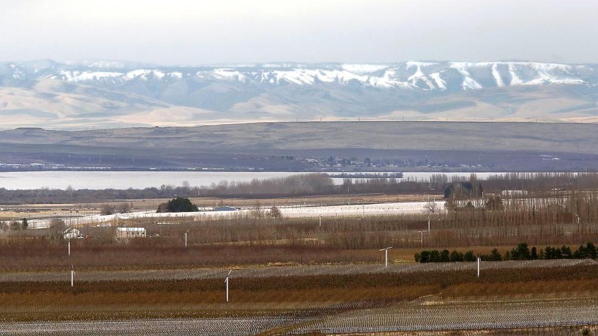 The snow-capped Blue Mountains are cloaked in clouds Wednesday afternoon with orchards and other agricultural fields in Finley visible in the foreground. Experts say the snow pack for the lower and upper Yakima Basin is not far below normal for the winter to date even though the Tri-Cities have only received about 4 inches of snowfall so far this winter.