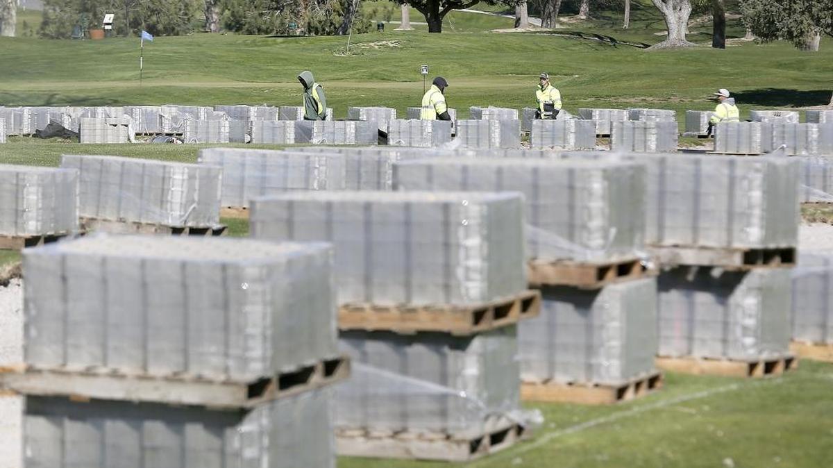 Workers from Harry Johnson Plumbing & Excavating in Walla Walla prepare to install dozens of pallets of concrete pavers Thursday at the Tri-City County Club golf course in Kennewick. The work is the culmination of a city of Kennewick project to clean out sediment from an underground 72-inch drainage pipe and stilling basin from Zintel Canyon Dam, said Ken Nelson, assistant public works director. The open blocks of concrete will allow grass to grow through and are being placed across the fairway along Kennewick Avenue to allow access for future maintenance and cleaning projects of the pipe that originates at West Seventh Avenue and South Vancouver Street. The installation should take a couple of weeks.