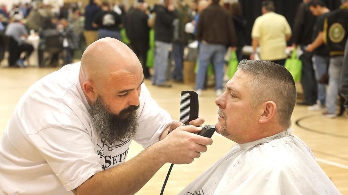 Volunteer barber Daniel Henkel, of Trend Setters in Kennewick, finishes up a free haircut and beard trim for David Hilpert, an Army veteran from Connell, Thursday morning at the 4th annual Veterans Appreciation Fair & Stand Down Event in Kennewick. Watch a video at: tricityherald.com.video