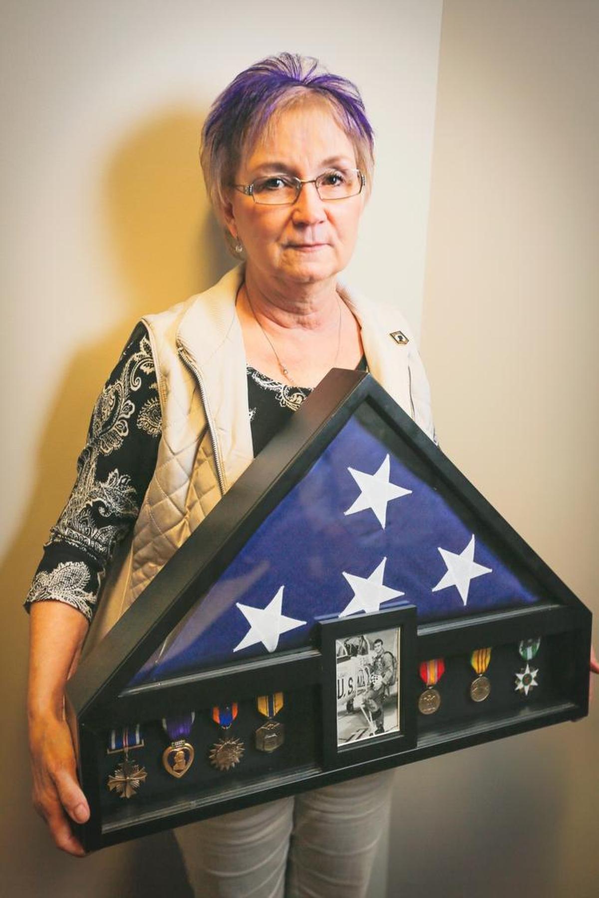 Terri Francisco-Ferrell poses for a photo holding a shadow box with a photo of her brother, San D. Francisco, his medals and U.S. flag. Francisco was in the Air Force and has been missing since he was shot down in the former North Vietnam on Nov 25, 1968.