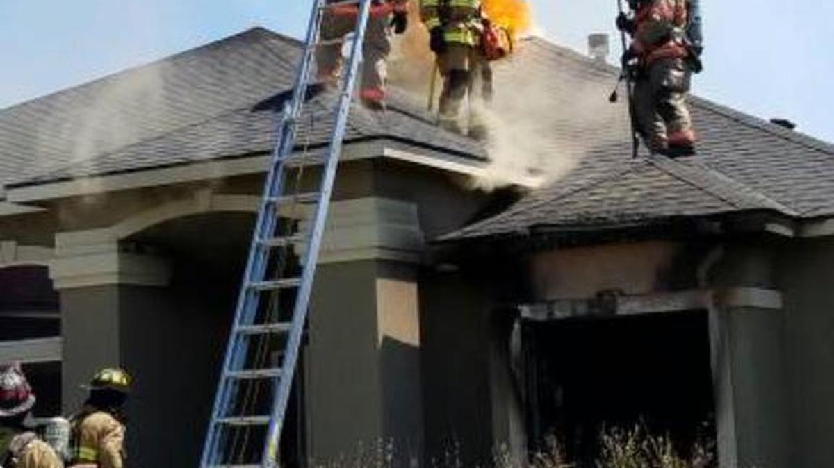 A neighbor carried a man found inside this burning west Kennewick home on Monday. Authorities are still investigating the cause of the blaze