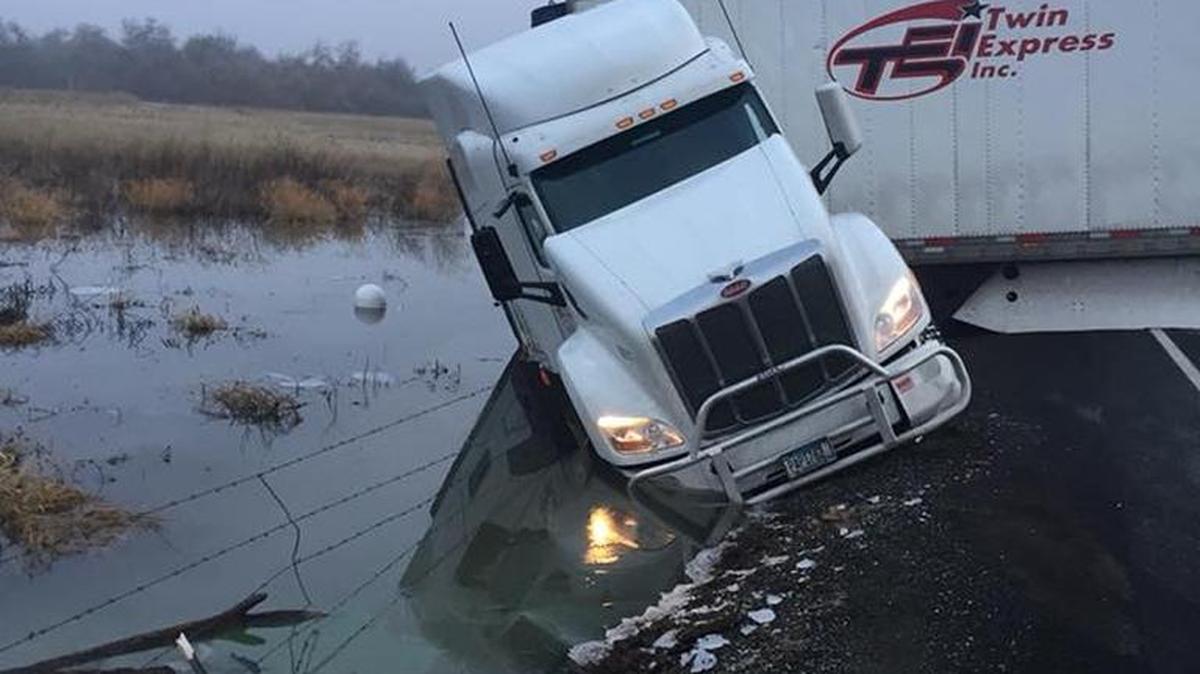 Twin Bridges Road is closed as police wait for a tow truck to pull this semi truck out of the ditch it slid into Saturday morning.