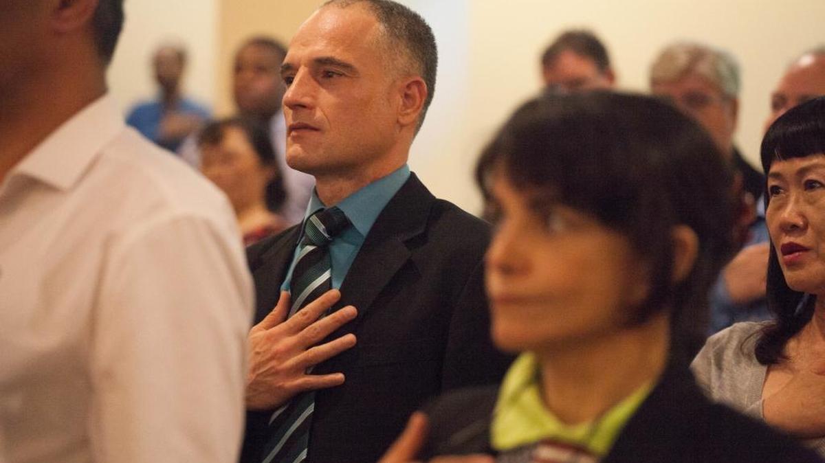 Mushtaq Jihad recites the Pledge of Allegiance during his naturalization ceremony at the U.S. Citizenship and Immigration Services field office in Seattle.