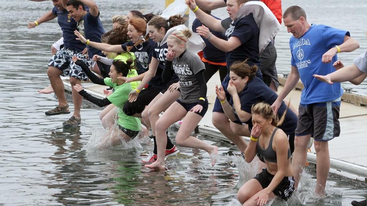 File: Teams drop into the 38-degree water of the Columbia River during the 2013 Polar Plunge to benefit Special Olympics. Local and state law enforcement organize the statewide fundraiser.