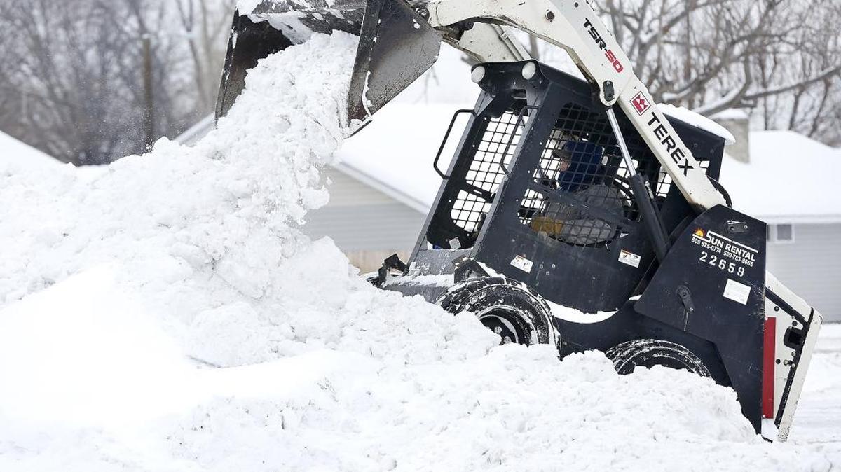 Brandon Shaver, owner of Grocery Outlet Bargain Market in Kennewick, dumps a bucket of snow he scraped from the store’s parking lot into a tall pile last month after one of several winter storms coated the Mid-Columbia.