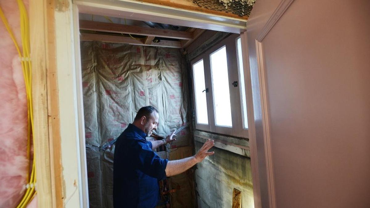 Tracy Bozen, co-owner of the Pendleton House, gestures to where a built-in closet dresser was where three bottles of Teacher’s Highland Cream whisky was discovered during recent renovations.