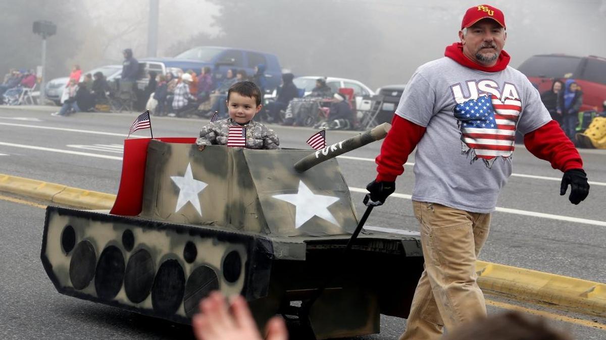 Curtis Graham pulls his son, Liam, 4, in a tank his wife made as they make their way down Van Giesen Street with Kids Space Preschool on Saturday morning during the annual Veteran’s Day Parade in West Richland. See more photos at tricityherald.com