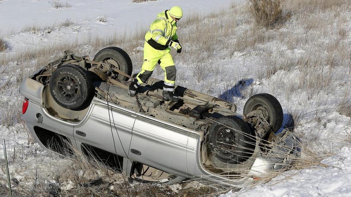 Danny Martinez, owner of Damar Towing in Pasco, walks on the undercarriage of an overturned vehicle Wednesday afternoon while attaching chains and cables to right the damaged car. Witnesses told Franklin County Sheriff deputies that the female driver was southbound on the Pasco-Kahlotus Highway, about three miles from Pasco, when she lost control and slid off the slick roadway. The unidentified woman, who was wearing a seat belt, had minor injuries from the crash, according Deputy Darrell Chambers. The roadway was temporarily closed while Martinez removed the wreck.