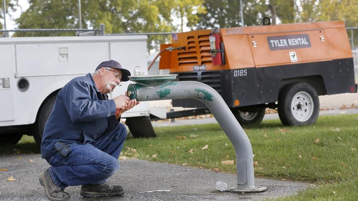 Kennewick City employee Bob Niebuhr reassembles an outdoor drinking fountain Tuesday at the skate park on South Dayton Street after using an air compressor to winterize the fountain and irrigation sprinklers at nearby city softball fields. Niebuhr said city employees have been busy winterizing city parks and other properties for the upcoming winter.