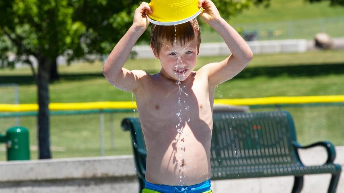 Micah Wattenburger, 7, dumps a bucket of water on his head while playing at the Splash and Play at Badger Mountain Community Park in Richland. Wattenburger was accompanied by his mother Tricia Wattenburger of Hermiston.