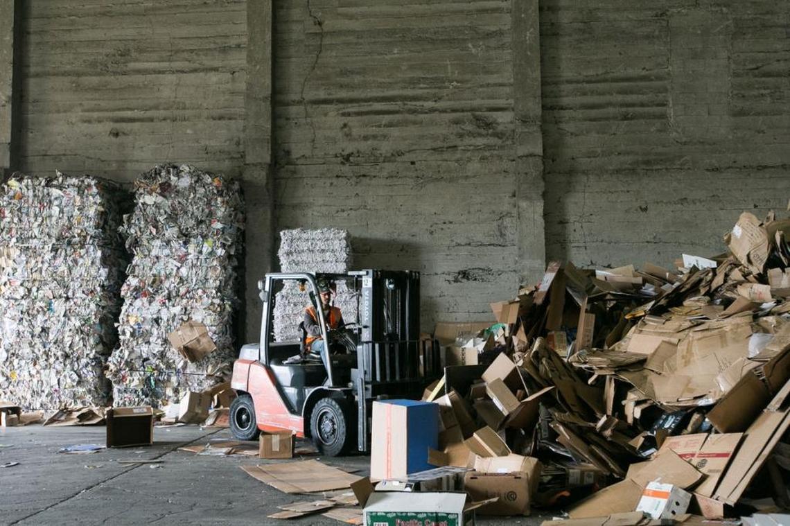 An employee at Central Washington Recycling pushes cardboard boxes through a processor Friday in Yakima.