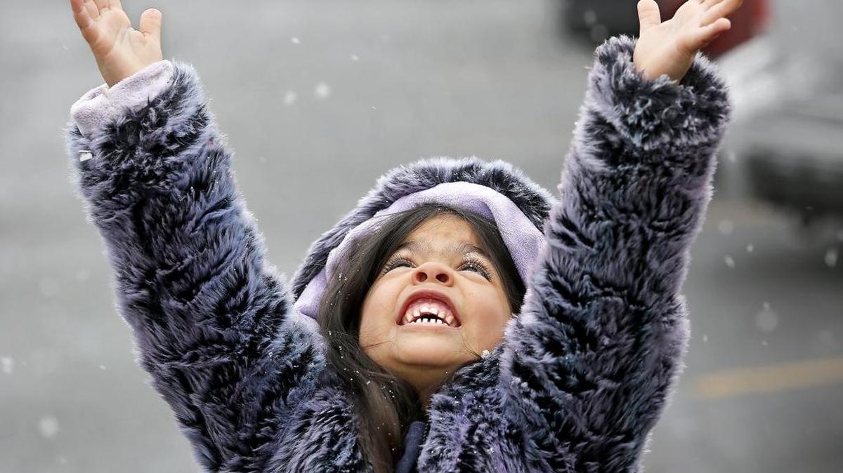 Audrina Lopez, 4, pauses while recently walking through a Kennewick parking lot to playfully try catching snowflakes that had stared falling. She was accompanied by her parents Irma and Mike Lopez of Kennewick.