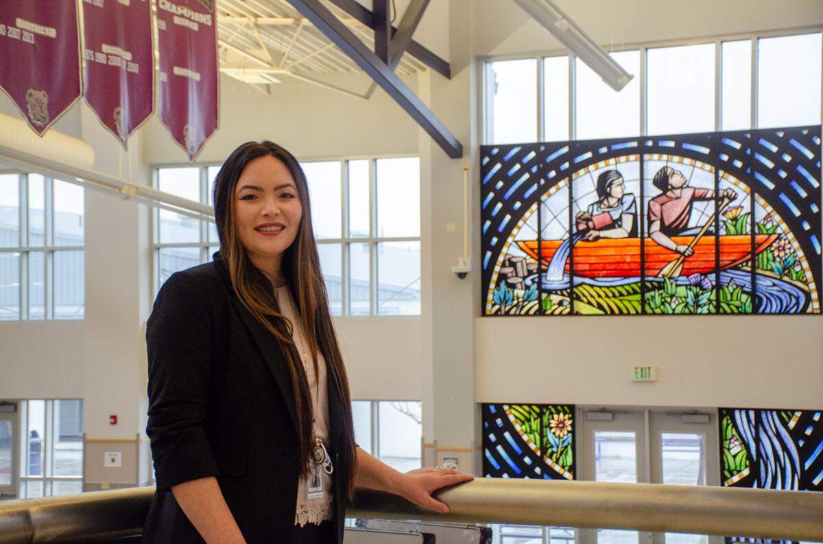 Pasco High School bilingual math teacher Gabriela Whitemarsh stands in front of Seattle artist Steve Gardner’s “Where Will You Go?” mural on campus. The 2010 piece depicts two people in a boat and focuses on the symbolic journey students make during and after high school.