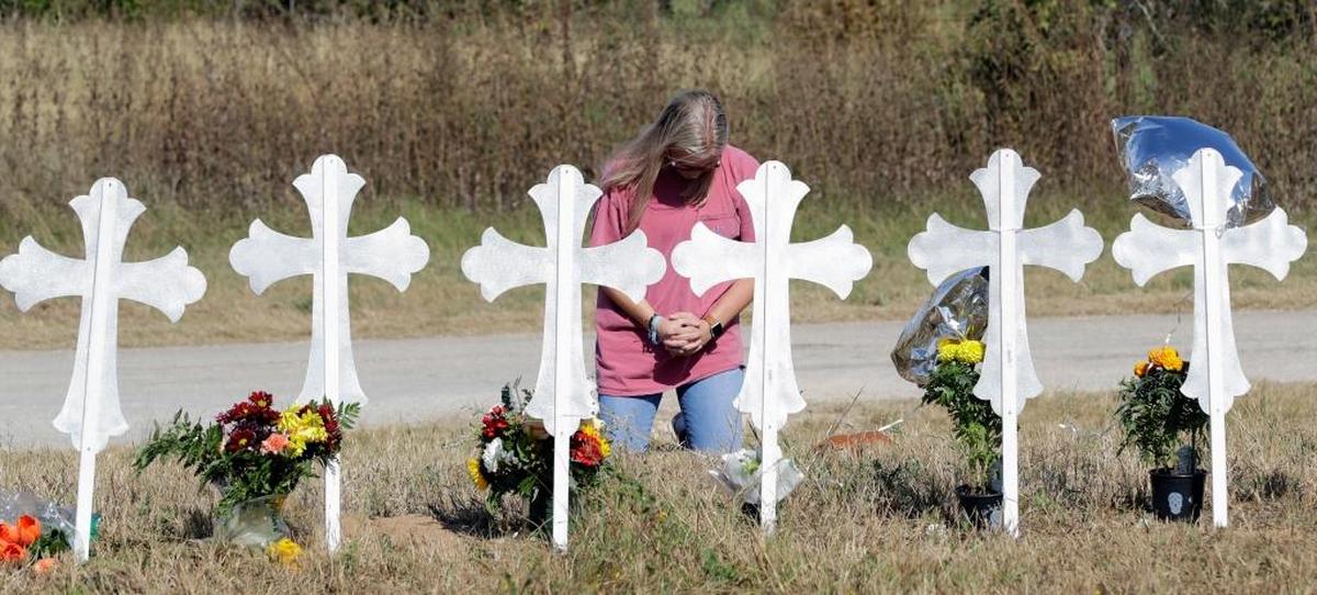 A woman kneels in prayer at a makeshift memorial for the First Baptist Church shooting victims Tuesdayin Sutherland Springs, Texas. A man opened fire inside the church in the small South Texas community on Sunday, killing more than two dozen and injuring others.