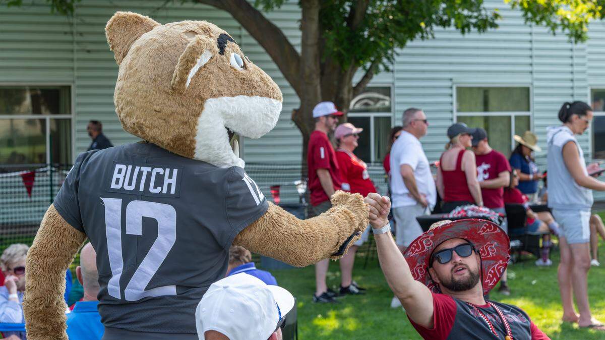 Mascot Butch T. Cougar gets a fist-bump from a Washington State University fan at a September game day watch party hosted at the Richland campus.