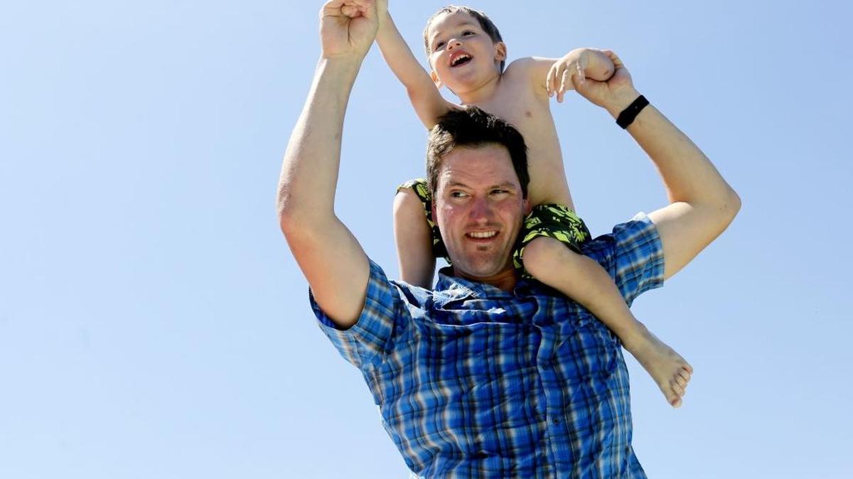 Patrick Killoran lifts his son, Parker, on his shoulders while playing at their home in Richland.