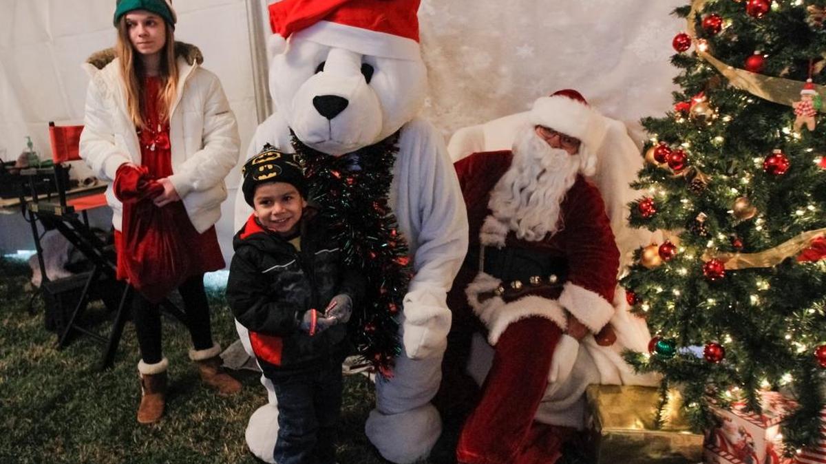 Jacob Cruz, 4, takes a photo with Santa Claus and his help from the North Pole during Pasco Winterfest on Saturday at Volunteer Park. Cruz was accompanied by his mother, Olga Blanco of Pasco.