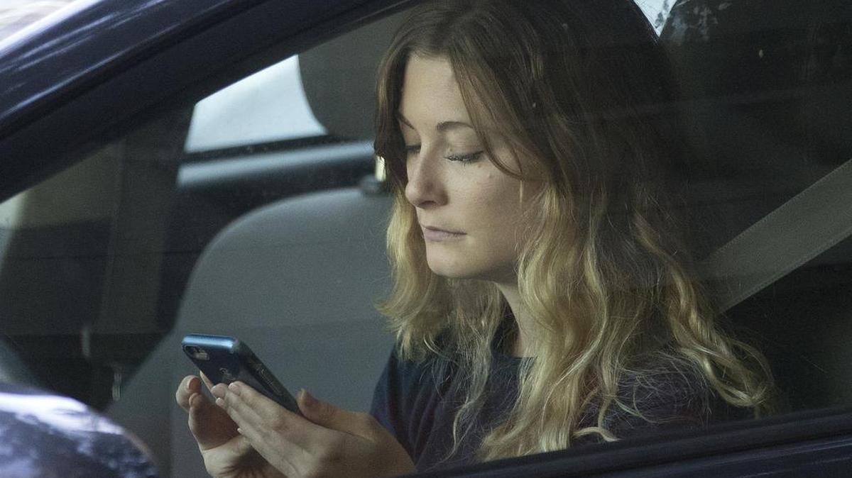 A driver uses her mobile phone while sitting in traffic in 2016, in Sacramento, Calif.