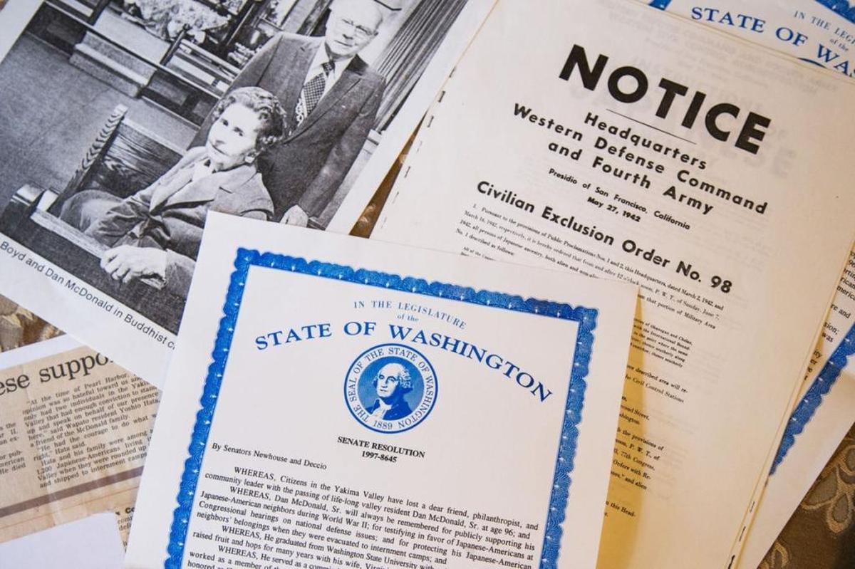 Historic counts, photographs and propaganda from the WWII Japanese internment camps are piled on the dining table at Paul McDonald’s home.