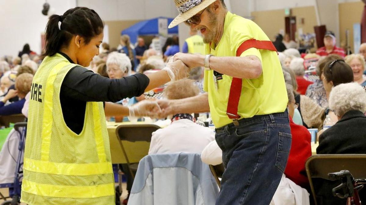 
Jennifer Miranda, 16, a Tri-Tech Skills Center firefighting student, dances with D.J. MacDonald, 86, of Richland, on Thursday during the 22nd annual All Senior Picnic at the Southridge Sports Pavilion in Kennewick. About 1,000 seniors attended the catered lunch, band and community information booths. Several student volunteer groups helped at the event organized by the Kennewick Senior Center. Watch a video at: www.tricityherald.com.
