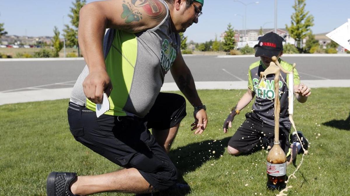 Dakota Moffatt, 12, of Pasco, and Eric Cardenas, executive chef at the Trios Southridge Hospital, react as a Mentos candy explodes in a bottle of Diet Coke on Wednesday during Camp Trios at the Southridge Sports Complex. The annual three-day summer camp is for kids with Type 1 diabetes. See a video at www.tricityherald.com/video.