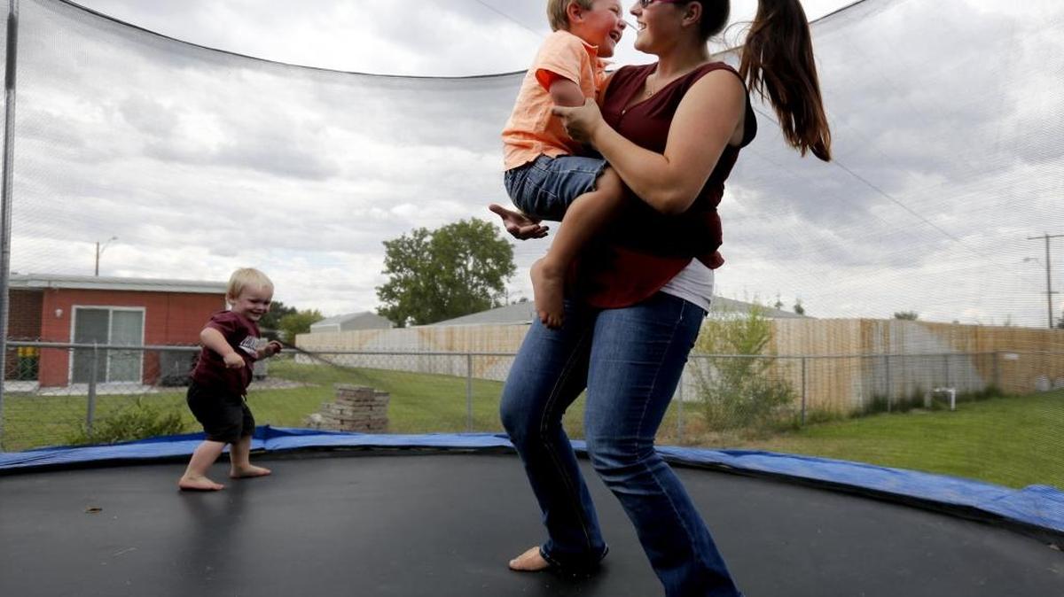 Hunter Aagaard jumps on a trampoline with his mother, Kristen Tisdale, and his younger brother, Kaiden, at their home in Kennewick.