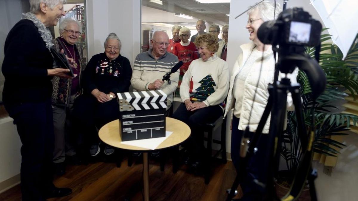 Residents at Brookdale Canyon Lakes laugh as they attempt to read the teleprompter during a rehearsal for their weekly news show, This Week at Canyon Lakes. From left, Tina Brumage, Myrlen McKinnon, Eleanor Ferreira, Art Swoboda, Ginger Vetrano and volunteer Margie Clark.