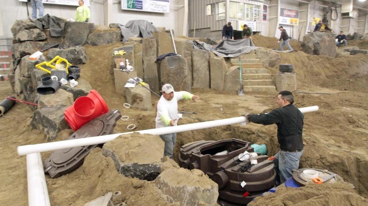 Workers install a water feature in the TRAC arena for the 2014 Regional Home & Garden Show. The Franklin County Commission is replacing a temporary floor in the arena, but hasn’t ruled out paving the dirt floor in the future to better accommodate similar events.