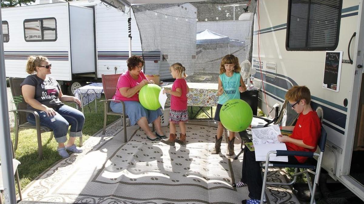 Tess Webster of West Richland, left, sits with family members near their small RV in the camping area at the Benton County Fairgrounds in Kennewick. Her mother, Cindy Dixon, helps her granddaughter Ione Wilson, 5, with a balloon while Jaylyn Wilson, 7, plays with hers. Webster’s son, Sam, 10 works with colored pencils in a coloring book while waiting his turn to show his pig. Watch a video at tricityherald.com/video