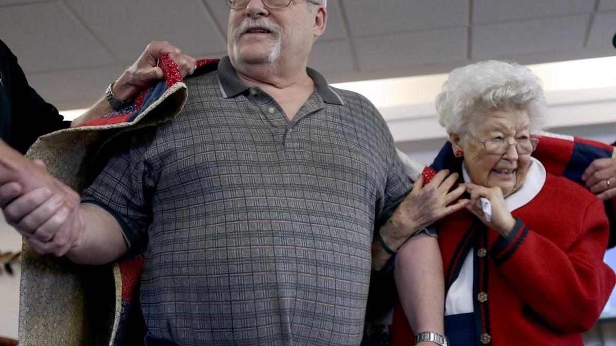Vietnam veteran Charlie “Skip” Gier, left, and Doris Brower, 96, are wrapped in the Quilt of Valor on Nov. 2 during a ceremony at the Brookdale Canyon Lakes retirement home in Kennewick. Brower made the quilt for Gier, a Vietnam veteran, as part of a national program which aims to cover service members and veterans touched by war with a quilt of comfort and healing. See a video at tricityherald.com/video