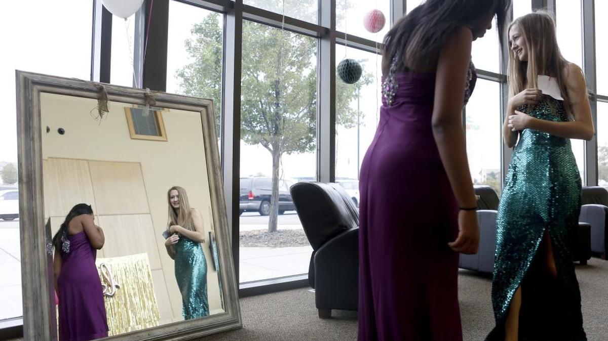 Friends Freya Coffey, left, and Bella Ghirardo, both seniors at Tri-Cities Prep, try on homecoming dresses Saturday during the Exchange for Change program at the Cynergy Center in Kennewick. The program, run by area high school students, works with Dresses for Hope and the Faith, Hope & Love Foundation to make sure every young girl has a chance to attend homecoming or prom in the dress of their dreams. They will hold another event in the spring for prom season.