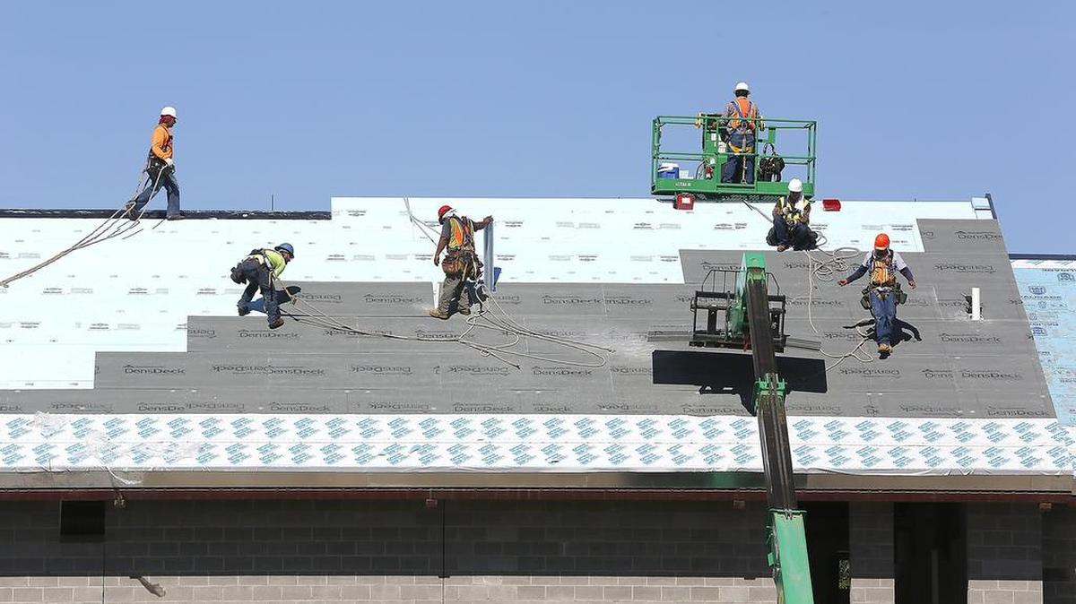 Roofers work on one of the buildings at the Port of Kennewick’s new Columbia Gardens Urban Wine & Artisan Village on east Columbia Drive in Kennewick. The Port expects to open the village to its two winery tenants in late August. Construction-related jobs were chiefly responsible for driving down unemployment in May.