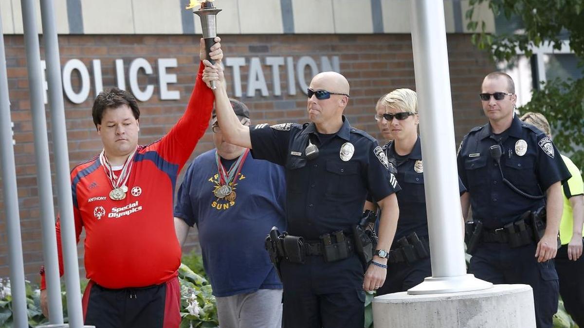 Special Olympics athlete Anthony Nash, left, of Kennewick, and Cpl. Matt Newton of the Kennewick Police Department lead a procession with the Flame of Hope during a ceremony Friday for the upcoming annual Law Enforcement Torch Run for Special Olympics Washington. Officers from across southeastern Washington have made a tradition of running the torch 384 miles across the state for the games held June 3-5 at Joint Base Lewis McChord and the King County Aquatics Center near Seattle. Watch a video at tricityherald.com/video