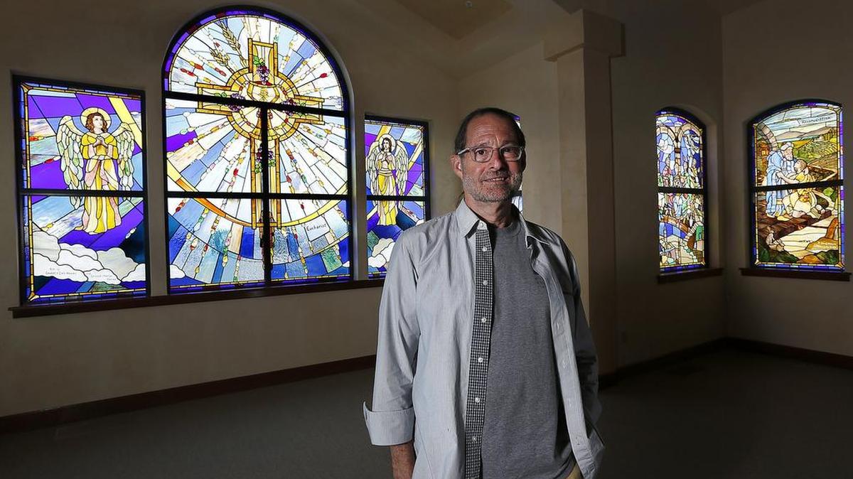 Stained glass artist Patrick Clark, a Richland native, stands near the second window installation he did for Tri-Cities Prep that represents the Catholic Sacraments. He first was invited 16 years ago to work with the Pasco school and its students on what’s become known as “The Unity Window.” He’s returned to the Tri-Cities to be interviewed for a book on the private school’s history.