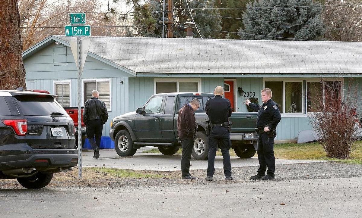 Kennewick police officers stand outside the house at 2303 W. 15th Place where and woman and young boy were injured Thursday by a suspected hash oil explosion and fire. See story on page 4A. Watch a video at: tricityherald.com/video