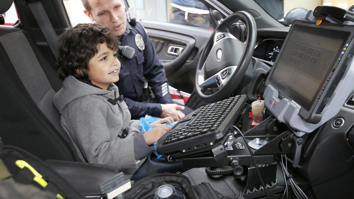 Miguel Santana, 8, sits in a Pasco police patrol car Monday as Officer Sean Granger shows him the controls for the emergency lights and siren while in the parking lot of Kadlec Regional Medical Center in Richland. Nurses and caregivers of the young cancer patient arranged the special visit after he repeatedly told them he wants to be a police officer when he grows up.