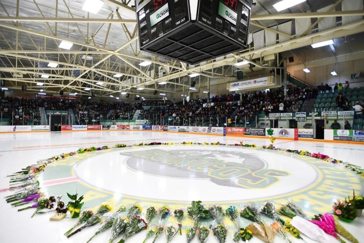 Flowers lie on the ice as people gather for a vigil Sunday at the Elgar Petersen Arena, home of the Humboldt Broncos, to honor the victims of a fatal bus accident.
