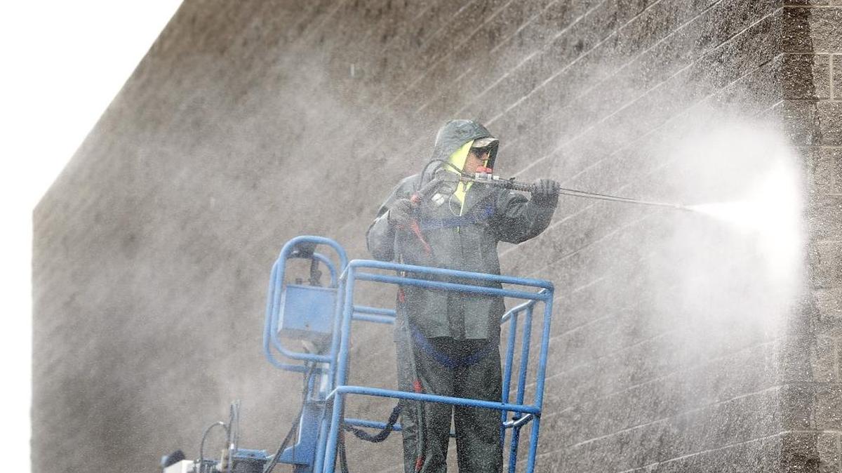 Aden Masonry employee John Landis is dressed for Tuesday’s rainy weather and for pressure washing the outside of a new Petco store under construction on the southwest corner of Road 68 and Burden Boulevard in Pasco. The new pet supply store is scheduled to open later this year.