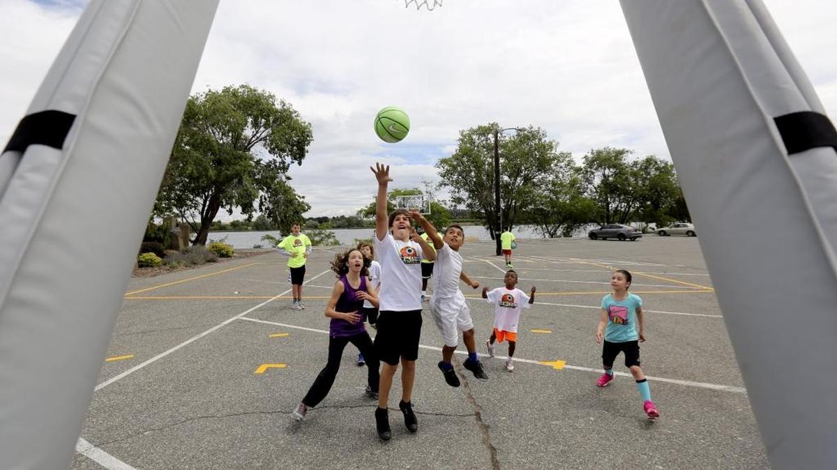 Skylar Hechinson, center, 13, attempts to make a basket as he is guarded by Rachel Euzek, left, 13, and JJ Reyes, 11, Friday during the Mike Brown Academy at Howard Amon Park in Richland. The youth basketball clinic was held in association with the See 3 Slam Tournament taking place on George Washington Way near John Dam Plaza in Richland on Saturday and Sunday. See a video at tricityherald.com.